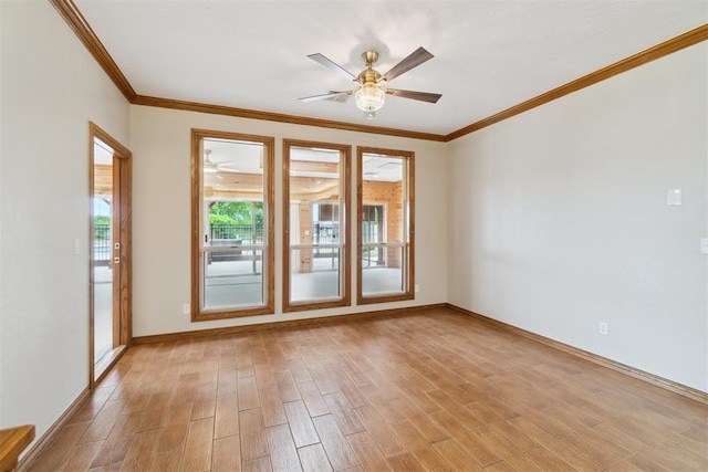 empty room with light wood finished floors, crown molding, a ceiling fan, and baseboards