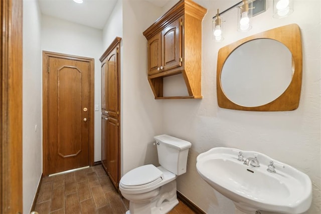 bathroom with a sink, toilet, and wood finished floors