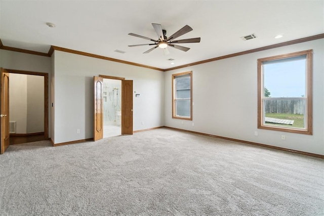 carpeted empty room with a ceiling fan, crown molding, and baseboards