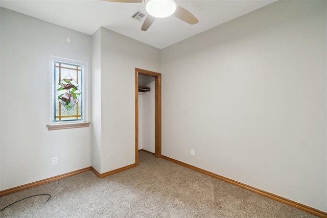 unfurnished room with light carpet, baseboards, and a ceiling fan