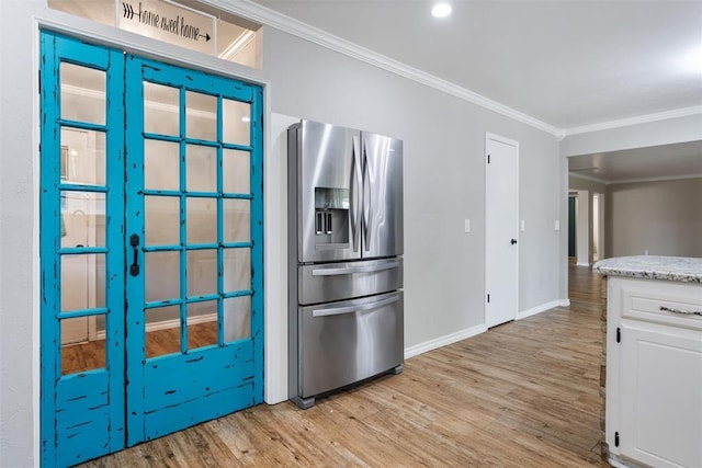 6408 Brentford Ter, Oklahoma City, OK 73132 - kitchen with stainless steel refrigerator with ice dispenser, light wood finished floors, crown molding, white cabinetry, and baseboards