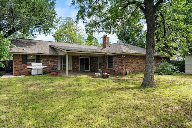 6408 Brentford Ter, Oklahoma City, OK 73132 - rear view of house featuring a ceiling fan, a chimney, a lawn, a patio area, and brick siding