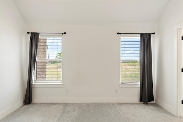 empty room with light carpet, healthy amount of natural light, and baseboards