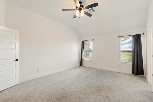 spare room featuring baseboards, light colored carpet, ceiling fan, and vaulted ceiling