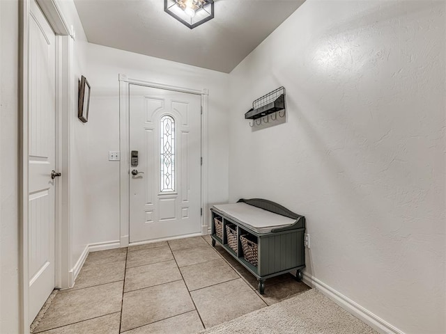 foyer featuring light tile patterned flooring and baseboards