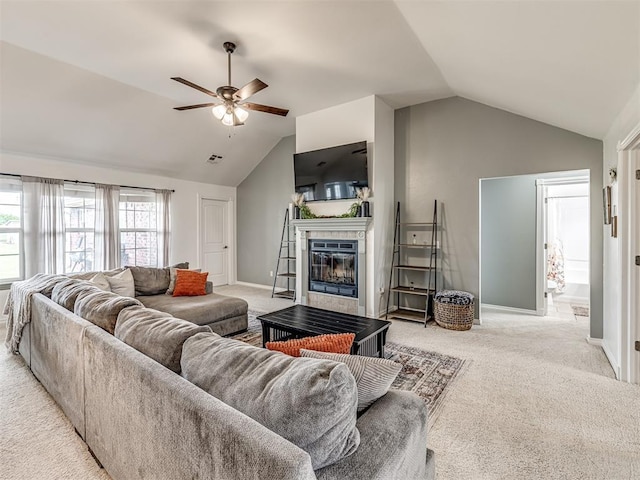 living area featuring lofted ceiling, light colored carpet, a fireplace, a ceiling fan, and baseboards