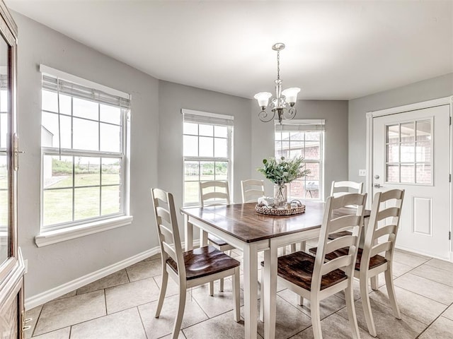 dining room with light tile patterned flooring, baseboards, and a chandelier