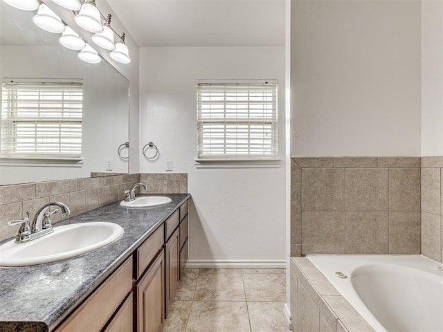 full bathroom featuring tile patterned floors, tiled bath, double vanity, and baseboards