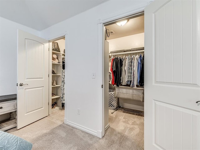 bedroom with a spacious closet, a closet, and carpet flooring