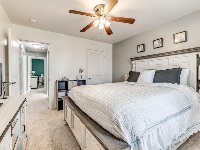 bedroom featuring light colored carpet, attic access, and ceiling fan