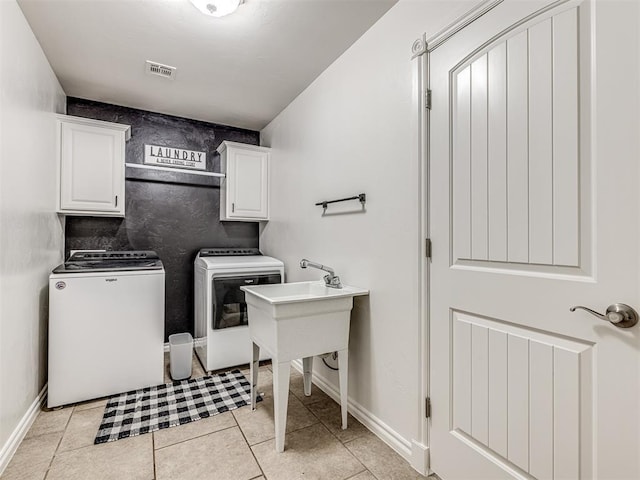 laundry room with cabinet space, washer and clothes dryer, light tile patterned flooring, and baseboards