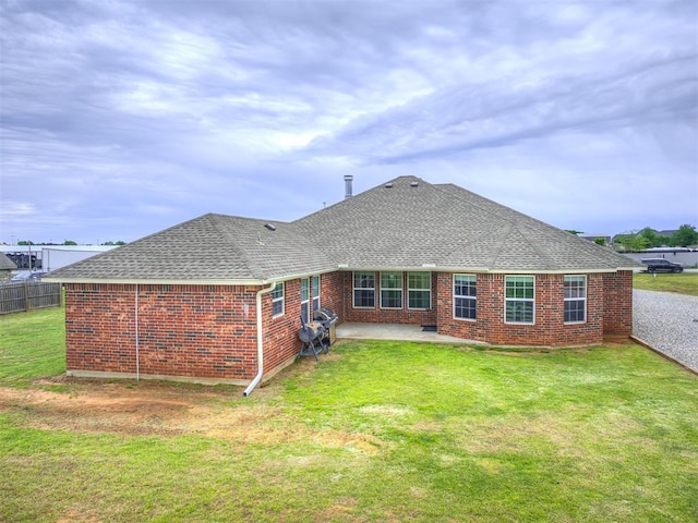 back of property featuring a shingled roof, a patio, and brick siding