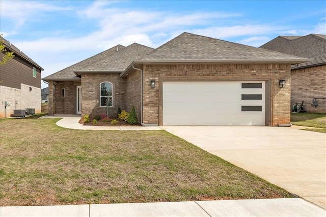 french country inspired facade with a shingled roof, brick siding, driveway, an attached garage, and a front lawn