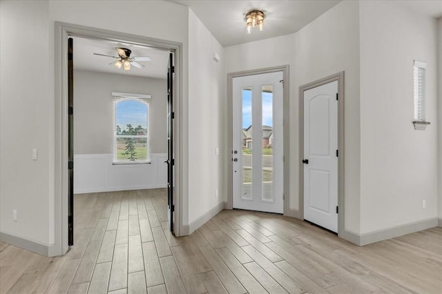 entryway featuring light wood-style flooring, a ceiling fan, and baseboards
