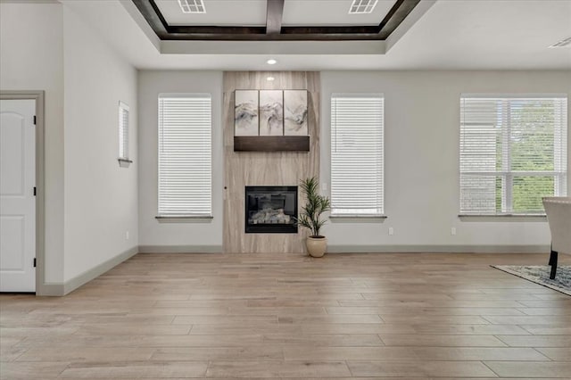 unfurnished living room with light wood-style flooring, a fireplace, baseboards, and recessed lighting