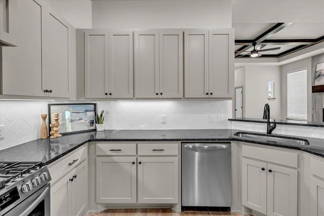 kitchen featuring stainless steel dishwasher, a sink, dark stone counters, tasteful backsplash, and coffered ceiling