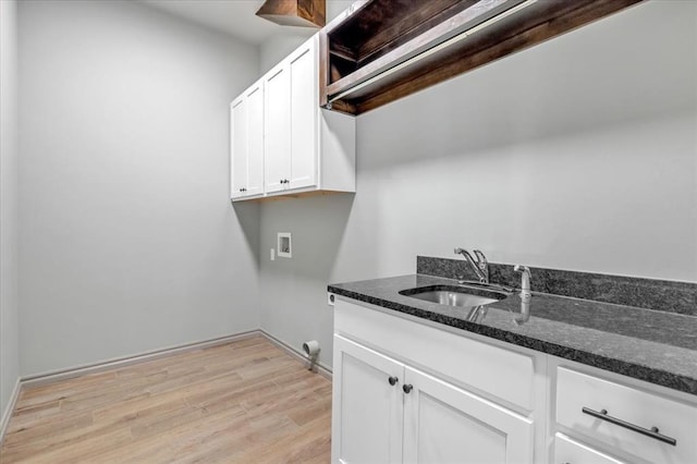 washroom with washer hookup, light wood-type flooring, cabinet space, and baseboards