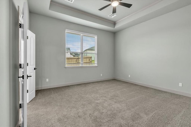 unfurnished bedroom featuring ornamental molding, a raised ceiling, carpet flooring, baseboards, and ceiling fan