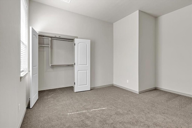 unfurnished bedroom with carpet floors, multiple windows, and baseboards