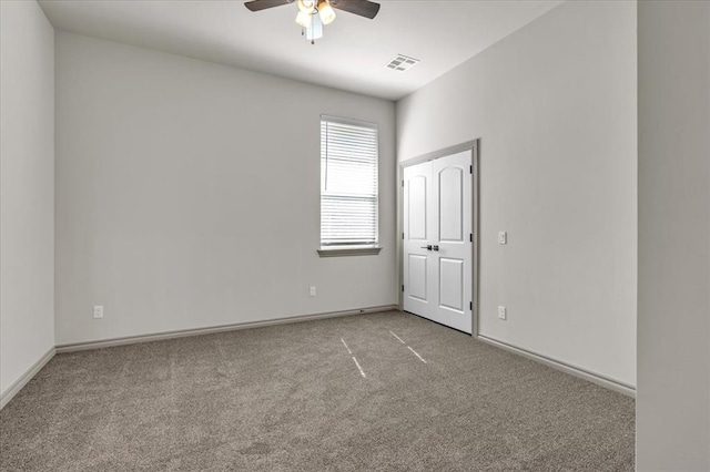 unfurnished room with carpet floors, a ceiling fan, and baseboards