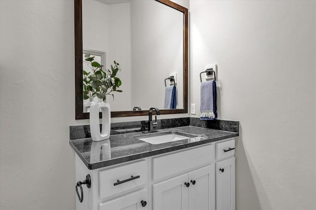 bathroom with a textured wall and vanity