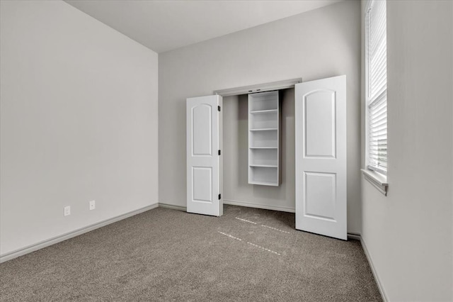 unfurnished bedroom featuring carpet and baseboards