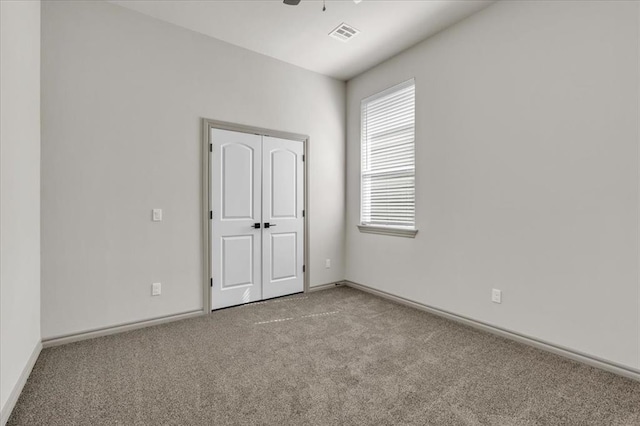 spare room featuring carpet floors and baseboards