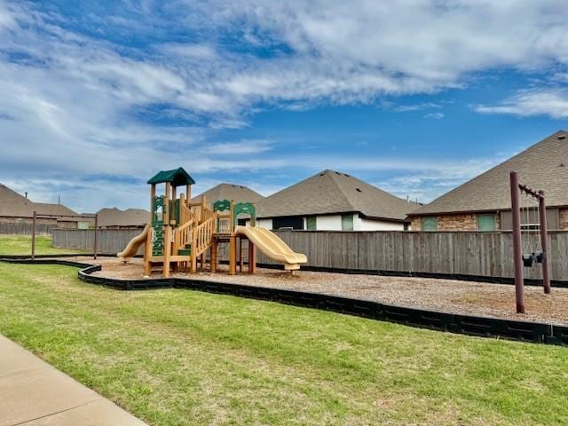 community playground featuring fence and a lawn