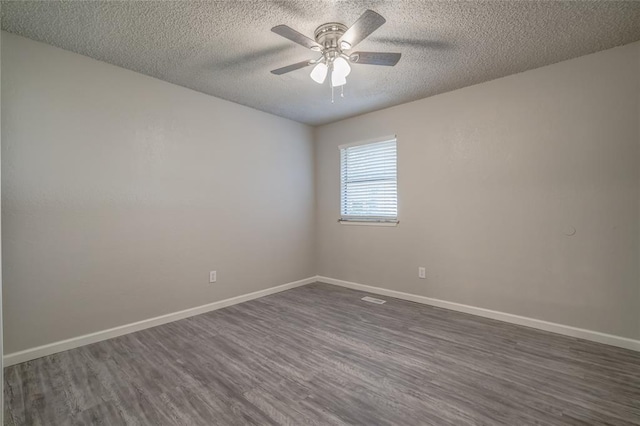 7301 Kings Manor Ct, Oklahoma City, OK 73132 - empty room with dark wood-style floors, a textured ceiling, a ceiling fan, and baseboards