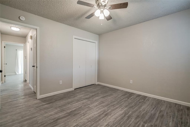 7301 Kings Manor Ct, Oklahoma City, OK 73132 - unfurnished bedroom with a textured ceiling, wood finished floors, a closet, and baseboards