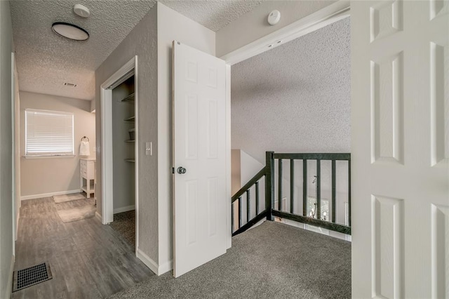 7301 Kings Manor Ct, Oklahoma City, OK 73132 - hall with a textured ceiling, an upstairs landing, and baseboards