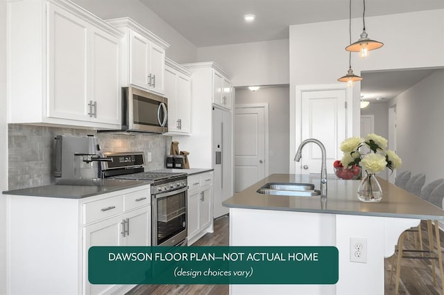 kitchen with appliances with stainless steel finishes, a sink, a kitchen island with sink, white cabinetry, and tasteful backsplash