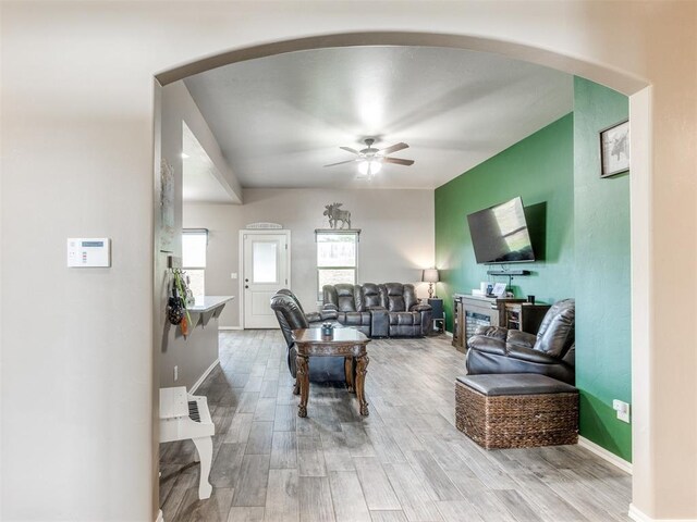 5702 Cedar Tree Cir, Guthrie, OK 73044 - living area featuring wood finished floors, ceiling fan, arched walkways, and baseboards