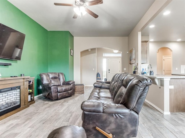 5702 Cedar Tree Cir, Guthrie, OK 73044 - living room featuring arched walkways, ceiling fan, wood finished floors, baseboards, and recessed lighting