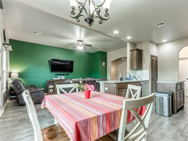 5702 Cedar Tree Cir, Guthrie, OK 73044 - dining space with arched walkways, light wood-type flooring, a ceiling fan, recessed lighting, and a chandelier