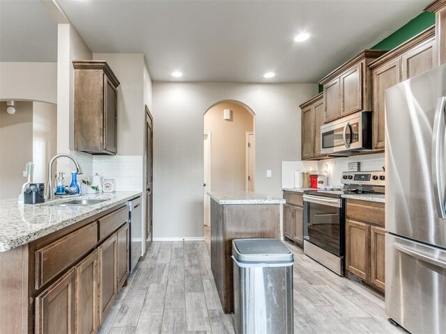 5702 Cedar Tree Cir, Guthrie, OK 73044 - kitchen with stainless steel appliances, arched walkways, a sink, tasteful backsplash, and recessed lighting