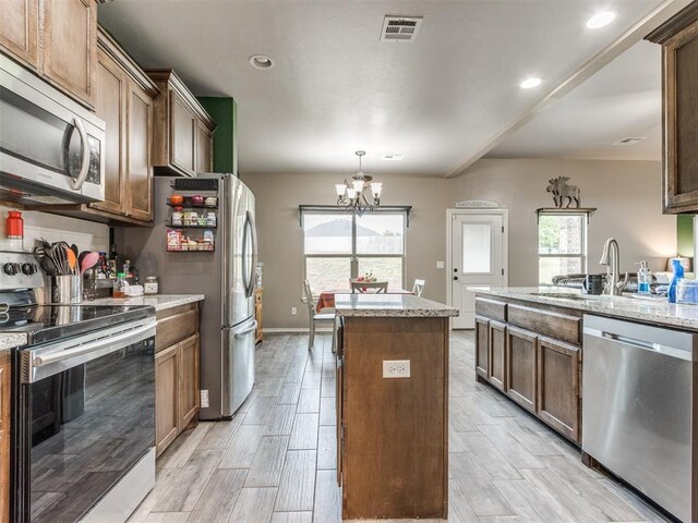 5702 Cedar Tree Cir, Guthrie, OK 73044 - kitchen with appliances with stainless steel finishes, a kitchen island, a chandelier, light wood finished floors, and recessed lighting