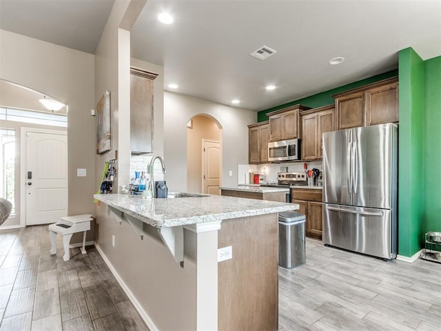 5702 Cedar Tree Cir, Guthrie, OK 73044 - kitchen with appliances with stainless steel finishes, a sink, a peninsula, light wood-type flooring, and recessed lighting
