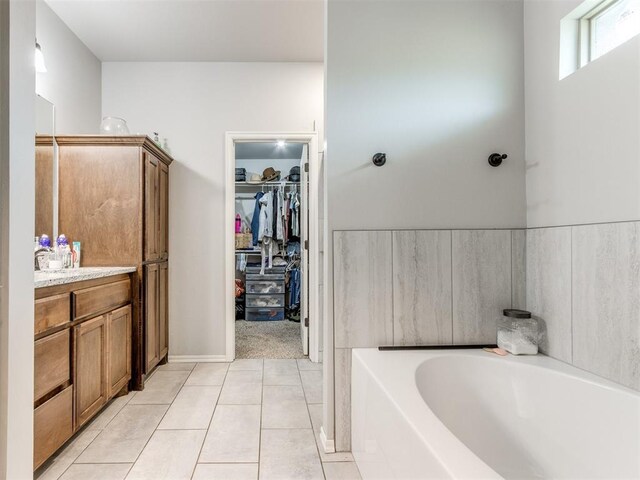 5702 Cedar Tree Cir, Guthrie, OK 73044 - full bathroom featuring a bath, tile patterned floors, a walk in closet, and vanity