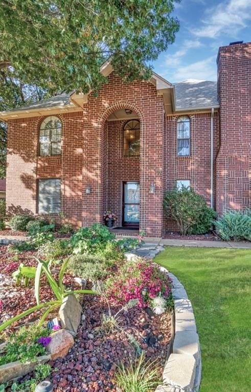 property entrance featuring brick siding and a yard