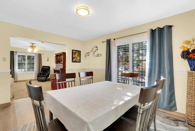 dining area with plenty of natural light, a ceiling fan, and wood finished floors