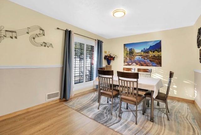 dining space with wood finished floors and baseboards