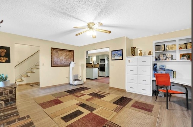 office with a textured ceiling, ceiling fan, wood finished floors, and baseboards