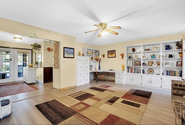 mudroom featuring ceiling fan, light wood-style floors, a textured ceiling, and built in desk