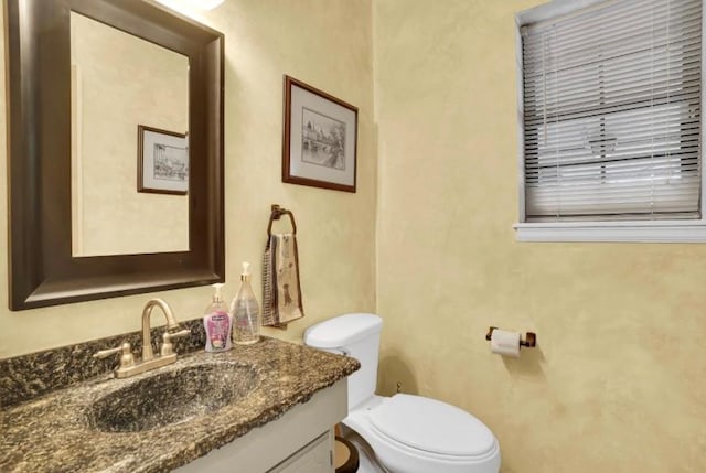 half bath featuring toilet and vanity