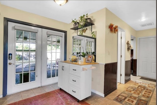 doorway to outside with french doors and light tile patterned flooring