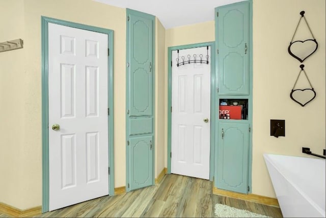 bathroom featuring wood finished floors and a freestanding tub