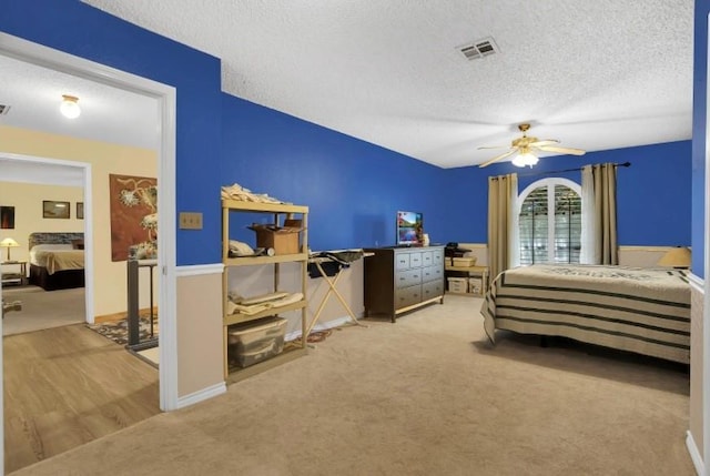carpeted bedroom featuring a textured ceiling, ceiling fan, and baseboards