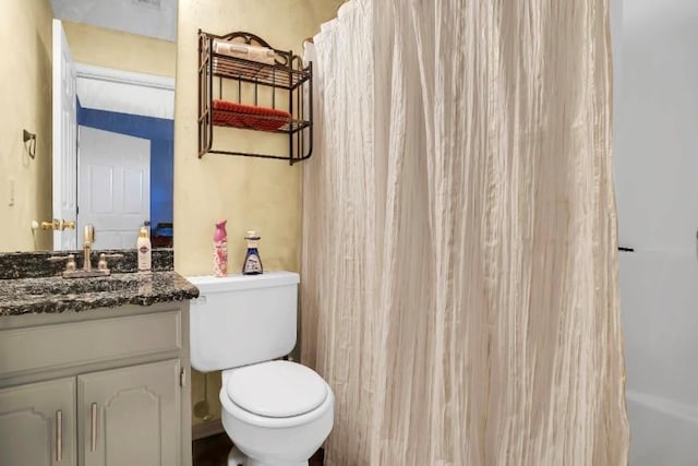 bathroom featuring vanity, a shower with shower curtain, and toilet