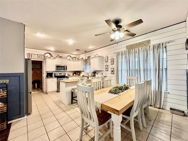 dining area featuring light tile patterned flooring and a ceiling fan